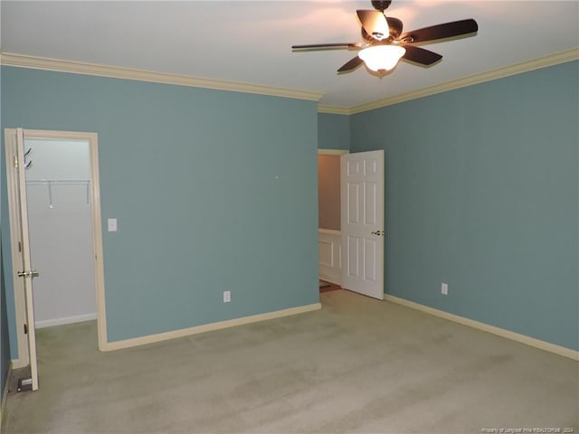 carpeted empty room with ceiling fan and ornamental molding