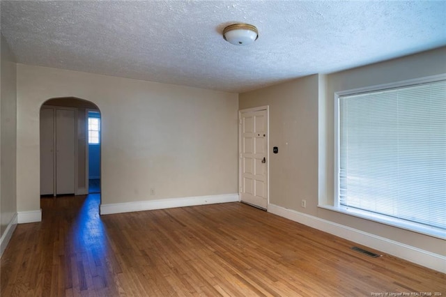 spare room featuring wood-type flooring and a textured ceiling