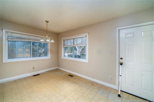 unfurnished dining area featuring a chandelier