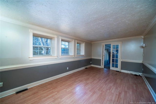 spare room with hardwood / wood-style floors, a textured ceiling, and ornamental molding