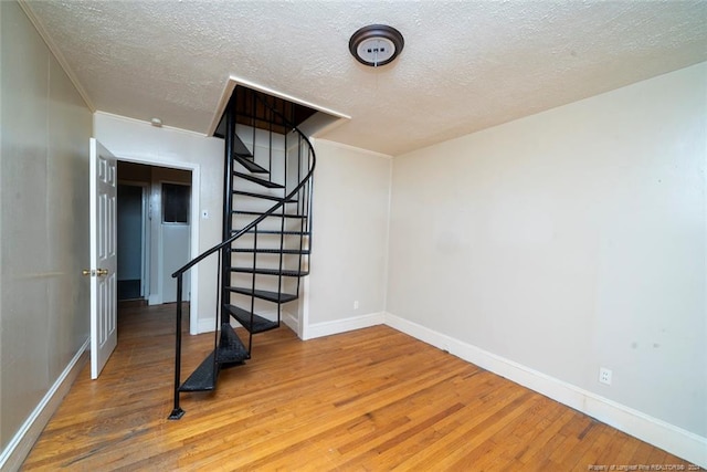 basement with hardwood / wood-style floors and a textured ceiling