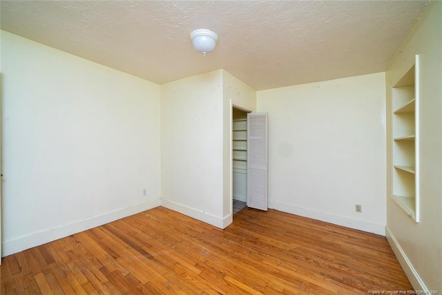 unfurnished bedroom featuring hardwood / wood-style floors and a textured ceiling