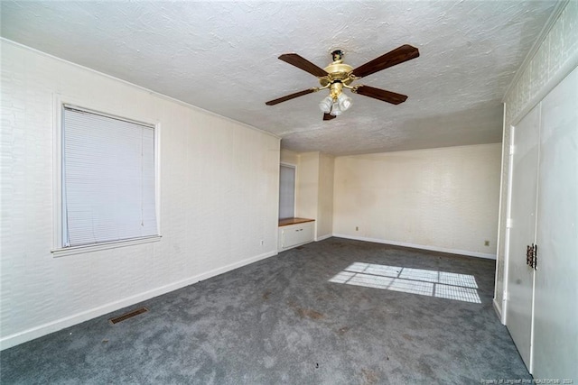 carpeted spare room with ceiling fan and a textured ceiling