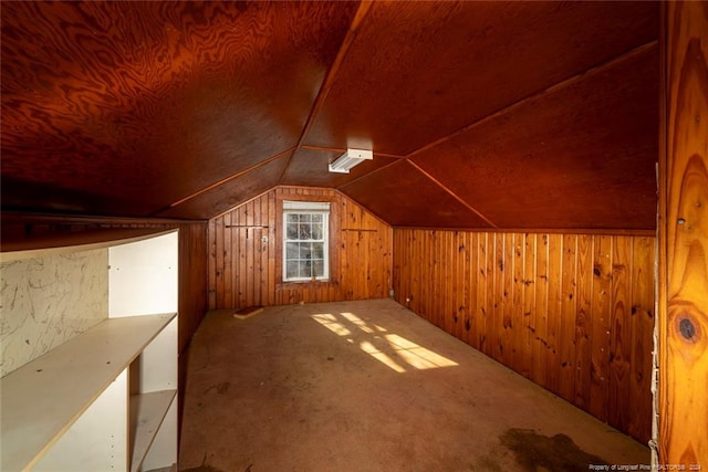 additional living space with wood walls, carpet, and lofted ceiling