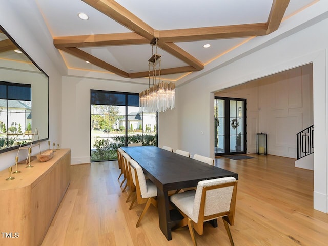 dining space featuring french doors, coffered ceiling, a notable chandelier, beamed ceiling, and light hardwood / wood-style floors