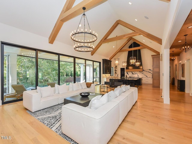 living room with a chandelier, beam ceiling, high vaulted ceiling, and light hardwood / wood-style flooring