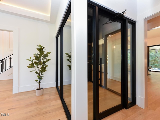 hallway with light hardwood / wood-style floors