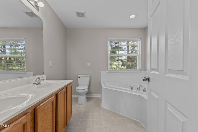 bathroom featuring vanity, a relaxing tiled tub, and toilet