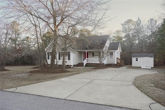 cape cod-style house with a storage unit, covered porch, and a front yard