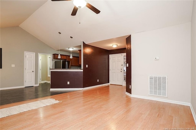 unfurnished living room featuring lofted ceiling, hardwood / wood-style floors, and ceiling fan