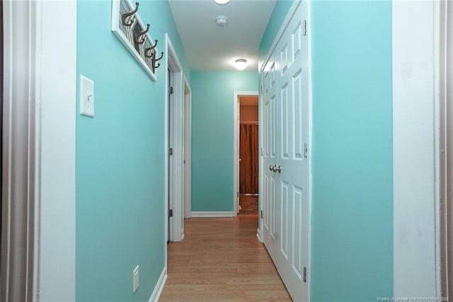 corridor with light hardwood / wood-style flooring