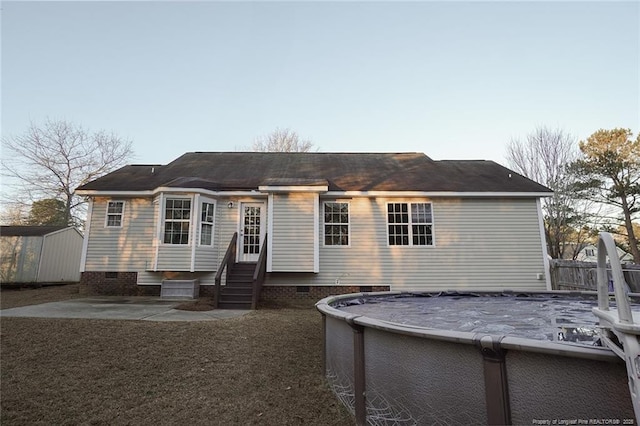 view of front facade with a storage unit, a covered pool, and a patio