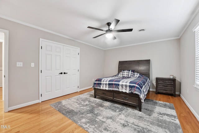 bedroom with crown molding, ceiling fan, a closet, and hardwood / wood-style floors