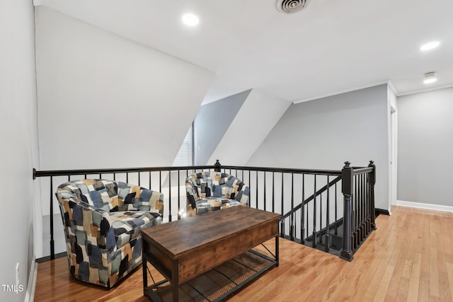 hallway with hardwood / wood-style floors and vaulted ceiling