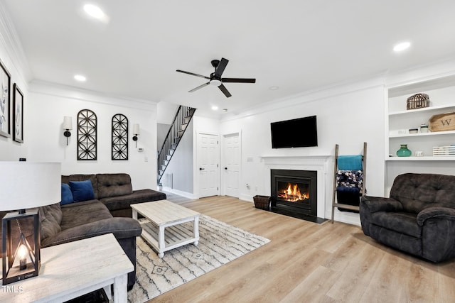 living room featuring ceiling fan, light hardwood / wood-style flooring, and ornamental molding