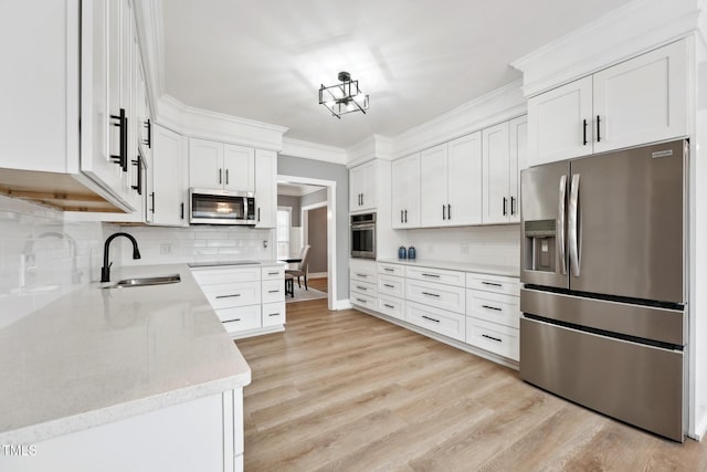 kitchen featuring decorative backsplash, stainless steel appliances, white cabinetry, and sink