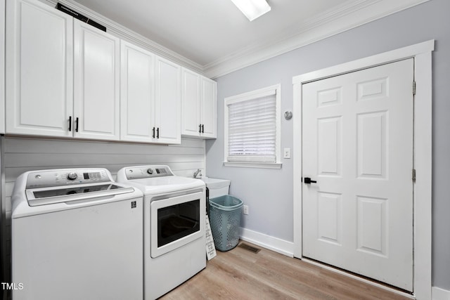 laundry room with sink, cabinets, washing machine and dryer, crown molding, and light wood-type flooring