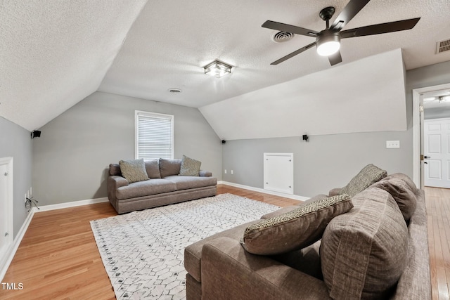 living room featuring hardwood / wood-style floors, lofted ceiling, and a textured ceiling