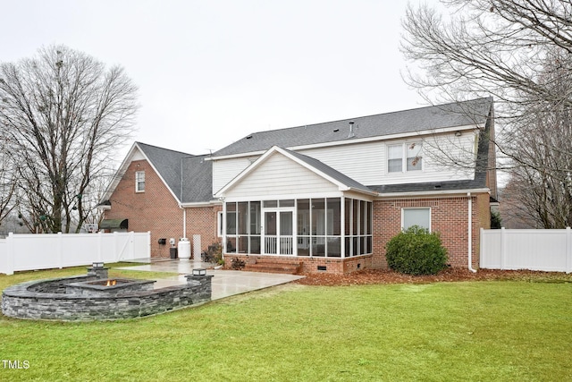 back of property with a yard, an outdoor fire pit, a patio area, and a sunroom