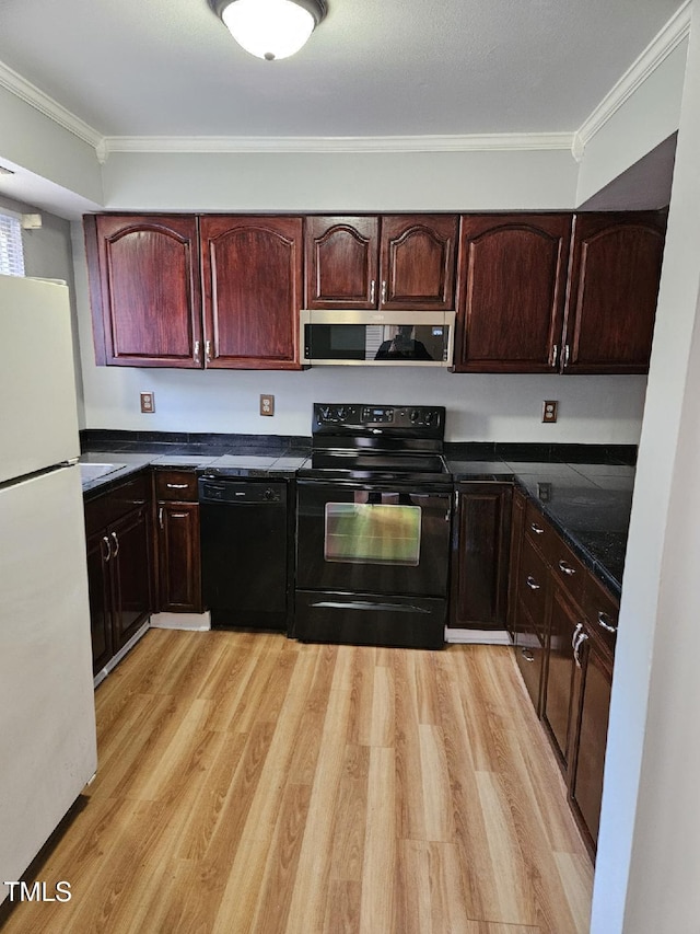 kitchen with light wood-type flooring, ornamental molding, and black appliances