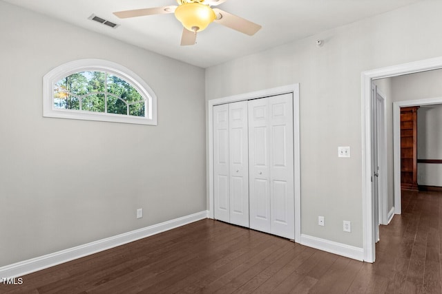 unfurnished bedroom with ceiling fan, a closet, and dark hardwood / wood-style floors