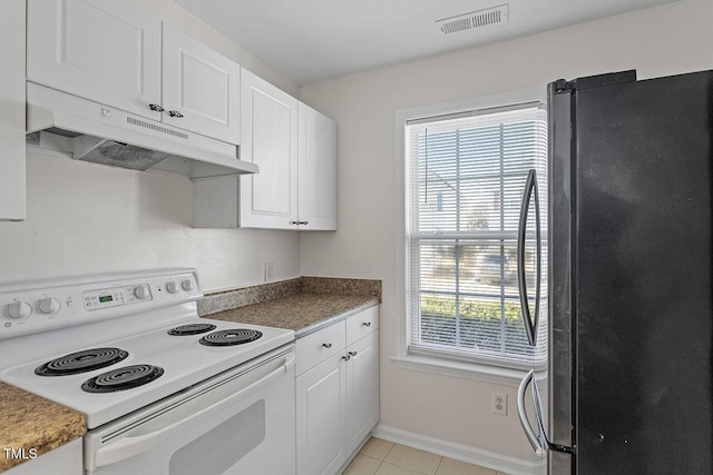 kitchen with white range with electric cooktop, a healthy amount of sunlight, white cabinetry, and stainless steel refrigerator