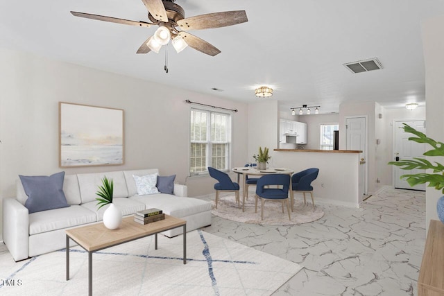 living room with ceiling fan and plenty of natural light