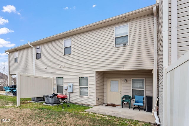 back of house with a yard and a patio