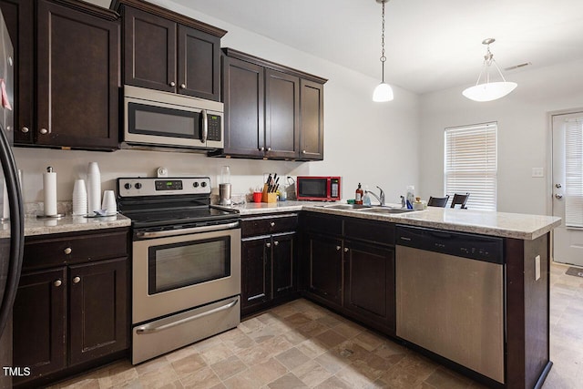 kitchen featuring pendant lighting, kitchen peninsula, sink, appliances with stainless steel finishes, and dark brown cabinetry