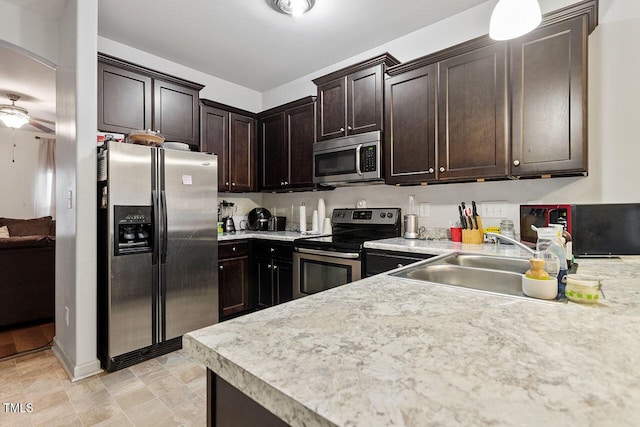 kitchen featuring appliances with stainless steel finishes, dark brown cabinetry, ceiling fan, and sink