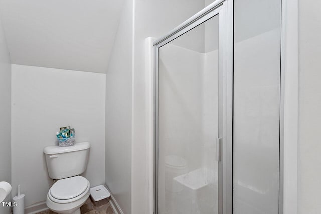 bathroom with vaulted ceiling, toilet, and an enclosed shower