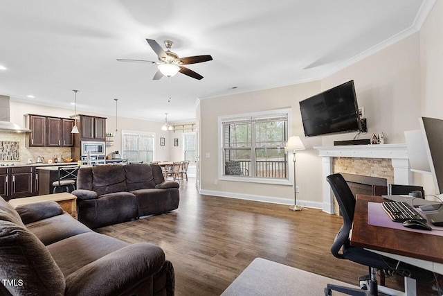 living room featuring hardwood / wood-style flooring, ceiling fan with notable chandelier, and ornamental molding