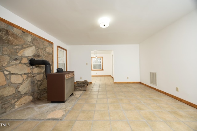 540 Patterson Dr, Chapel Hill, NC 27516 - living area featuring light tile patterned floors, baseboards, visible vents, and a wood stove