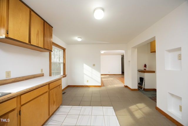 540 Patterson Dr, Chapel Hill, NC 27516 - kitchen with brown cabinetry, light countertops, baseboards, and light tile patterned flooring