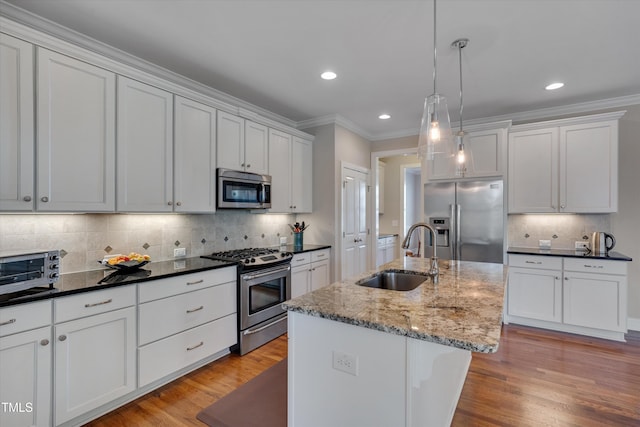 kitchen with sink, decorative light fixtures, white cabinetry, an island with sink, and appliances with stainless steel finishes