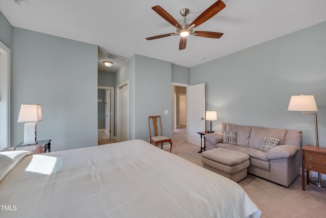 bedroom with ceiling fan, light colored carpet, and a closet