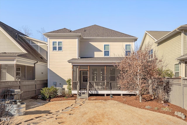 rear view of property featuring central AC and a sunroom