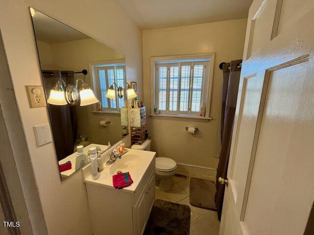 bathroom featuring tile patterned flooring, vanity, and toilet