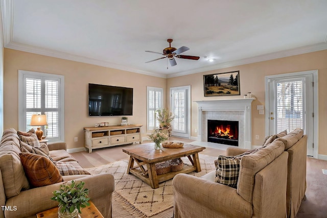 carpeted living room with a wealth of natural light, crown molding, and ceiling fan