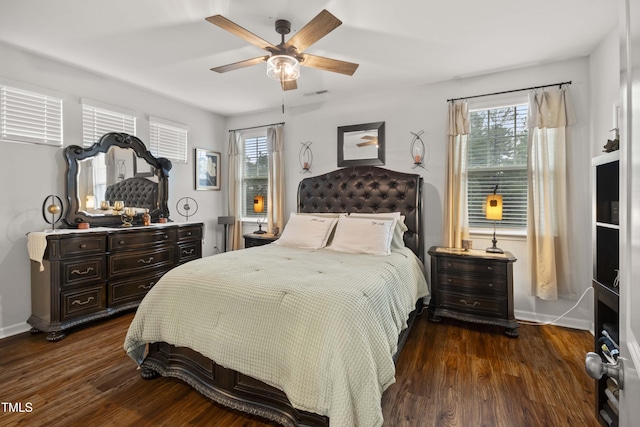 bedroom with visible vents, multiple windows, dark wood-type flooring, and baseboards