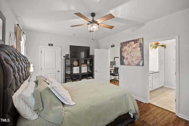 bedroom with hardwood / wood-style floors, ceiling fan, and ensuite bath