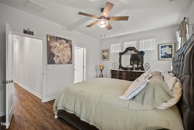 bedroom with visible vents, baseboards, wood finished floors, and a ceiling fan