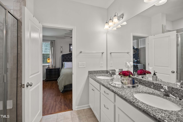 full bath with tile patterned flooring, a shower stall, connected bathroom, double vanity, and a sink