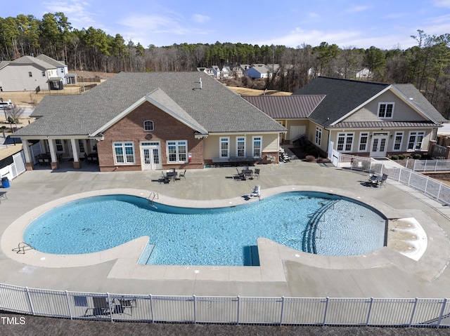 community pool with a patio area, french doors, and fence