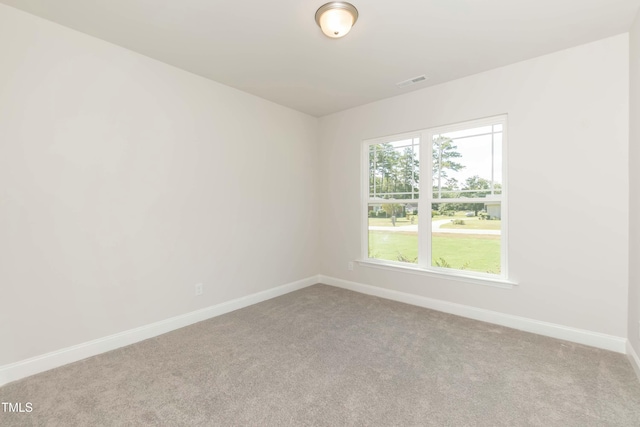 spare room featuring visible vents, carpet, and baseboards