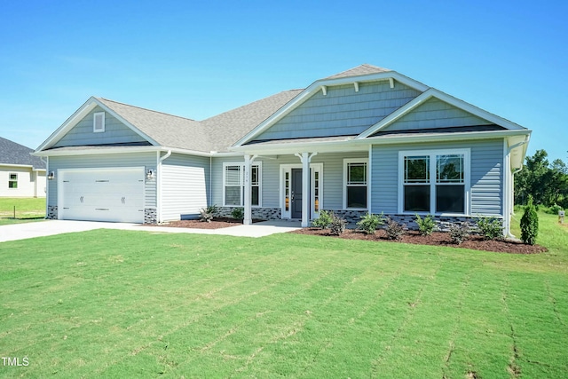 view of front of house featuring a front yard, concrete driveway, and an attached garage