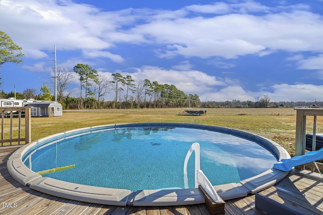 view of swimming pool featuring a yard and a rural view