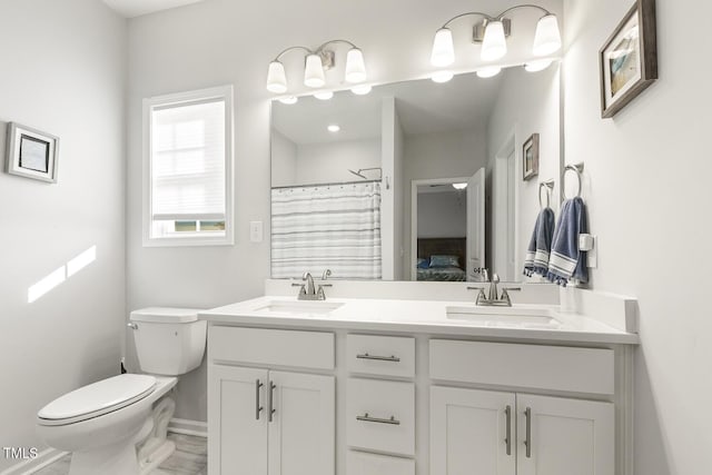 bathroom with walk in shower, vanity, and toilet