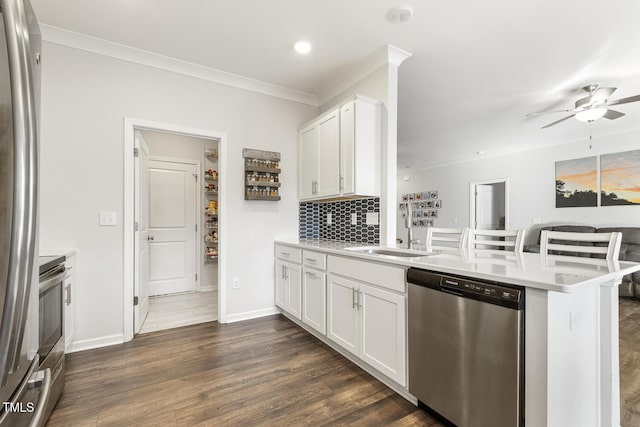 kitchen featuring kitchen peninsula, white cabinetry, sink, and appliances with stainless steel finishes