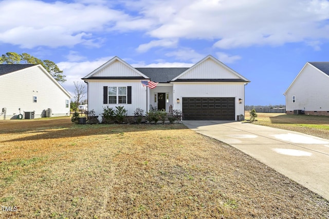 modern farmhouse featuring central air condition unit, a front yard, and a garage